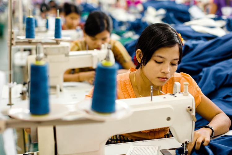 Asiatische Näherinnen bei der Arbeit in einer Fabrik.