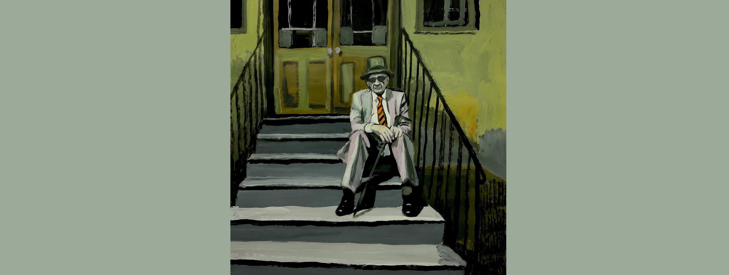 Ein älterer Mann sitzt im Anzug, Hut und Sonnenbrille auf einer Treppe vor einem Hauseingang und hält dabei einen geschlossenen Regenschirm zwischen seinen Beinen