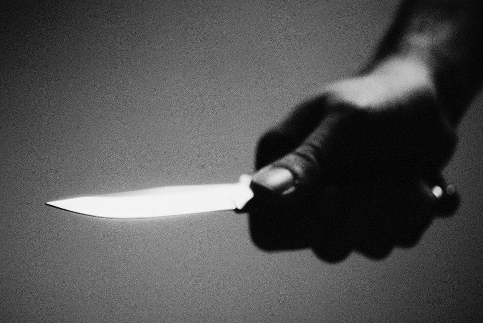 Ein Mann hält bedrohlich ein Messer in der Hand