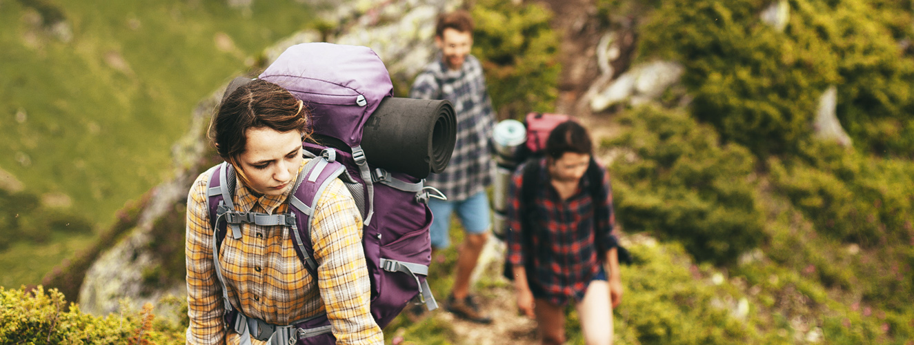 Das Foto zeigt eine Gruppe junger Menschen beim Wandern im Gebirge als Möglichkeit therapeutischen Arbeitens