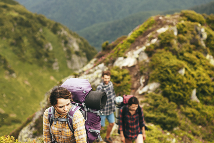 Das Foto zeigt eine Gruppe junger Menschen beim Wandern im Gebirge als Möglichkeit therapeutischen Arbeitens