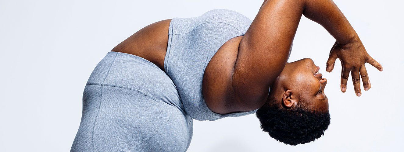 Das Foto zeigt die korpulente US-Amerikanische Yogalehrerin Jessamyn Stanley bei einer stehenden nach hinten gebeugten Yogapose.