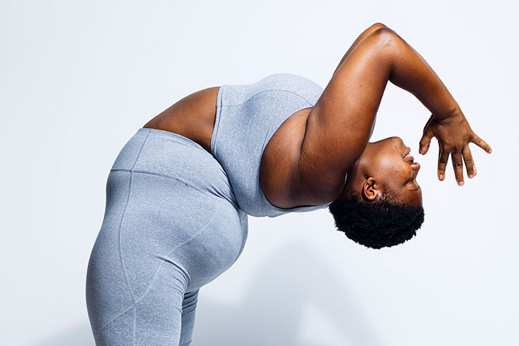 Das Foto zeigt die korpulente US-Amerikanische Yogalehrerin Jessamyn Stanley bei einer stehenden nach hinten gebeugten Yogapose