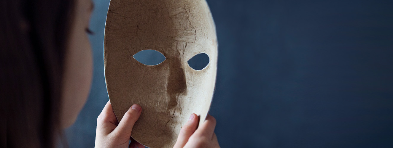 Eine psychopathische Frau hält eine Maske vor sich, im Begriff sich diese aufzusetzen