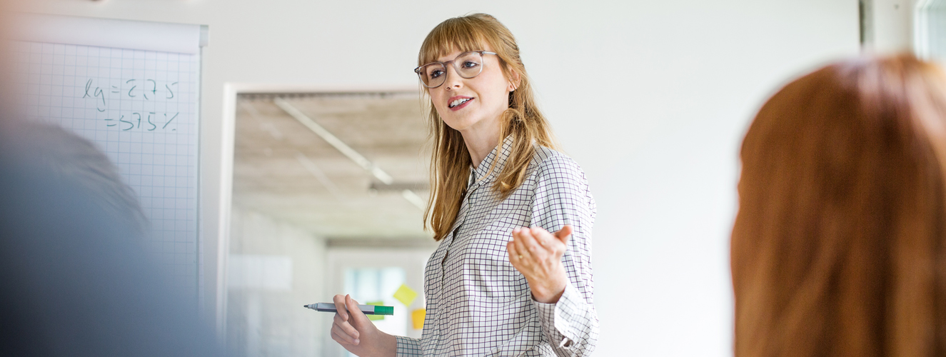 Foto zeigt eine introvertierte Frau, die vor Publikum spricht