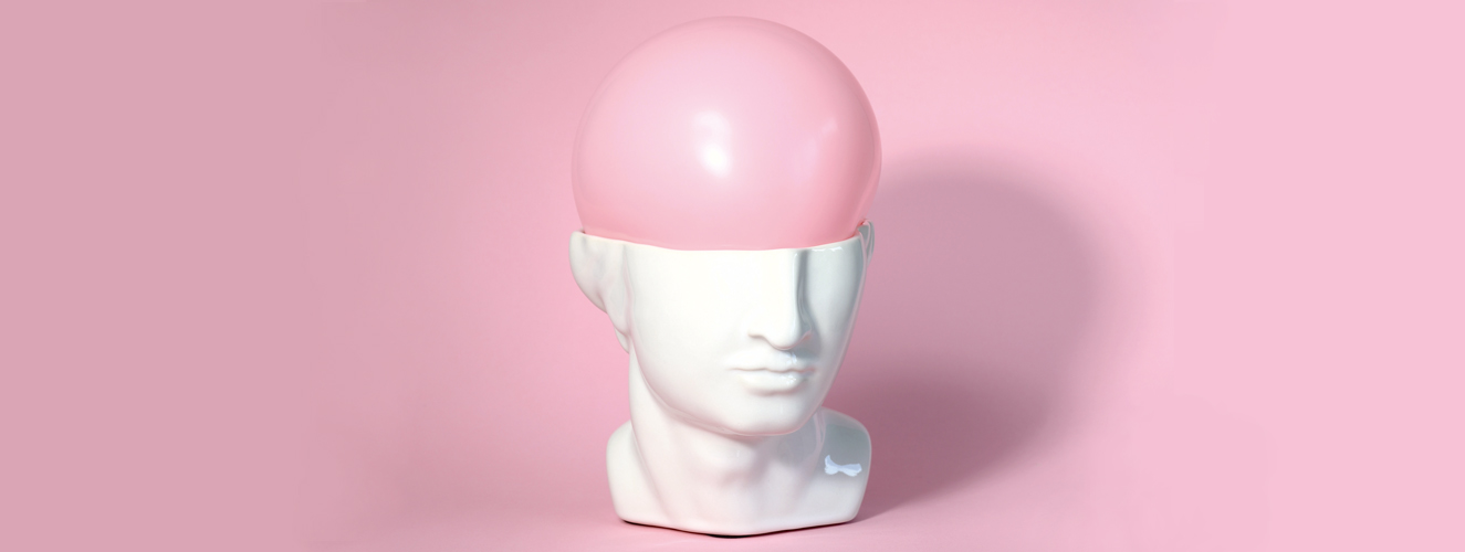 Foto zeigt einen Männerkopf aus Porzellan mit einem rosa Ballon als Gehirn