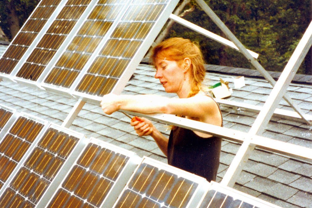 Eine Frau in der Kommune Twin Oaks arbeitet an einer Solarpanele