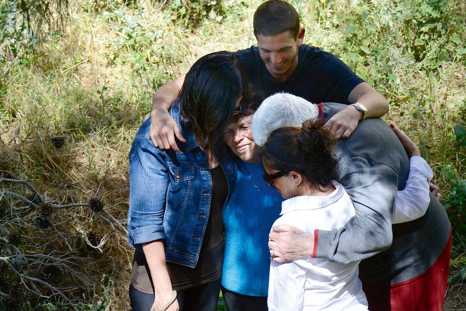 Eine Familie steht in ihrem Garten in Jerusalem und umarmt tröstend ein älteres Familienmitglied