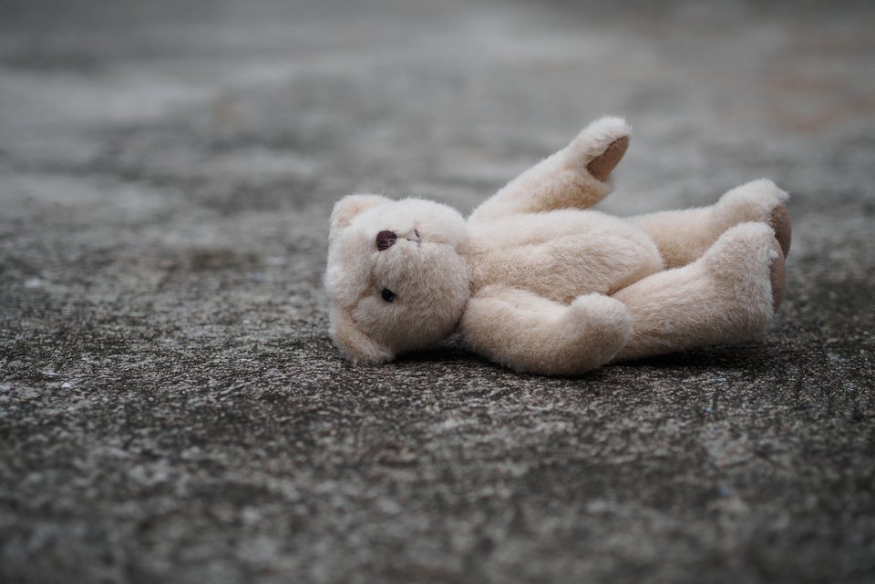 Ein Plüschteddybär liegt auf dem Boden