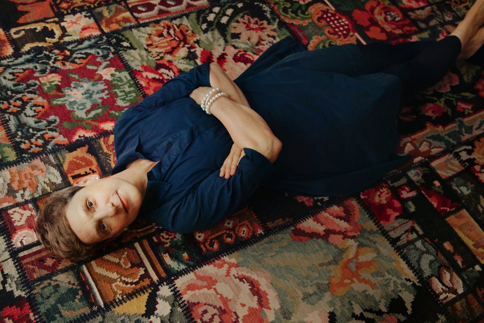 Die Schriftstellerin Felicitas Hoppe liegt entspannt und mit verschänkten Armen auf einem Teppich