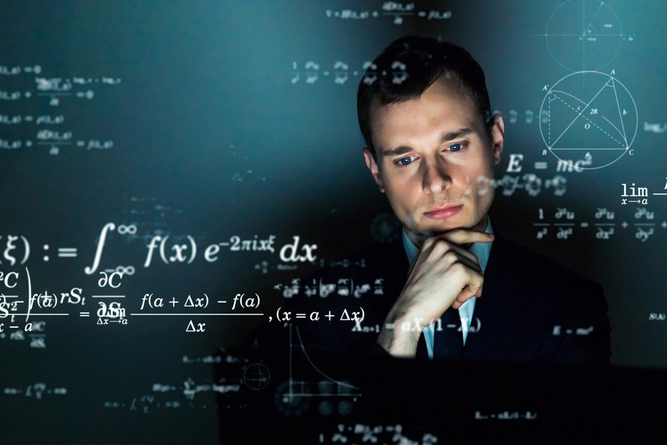 Ein junger Mann im dunklen Anzug denkt über mathematische Formeln nach