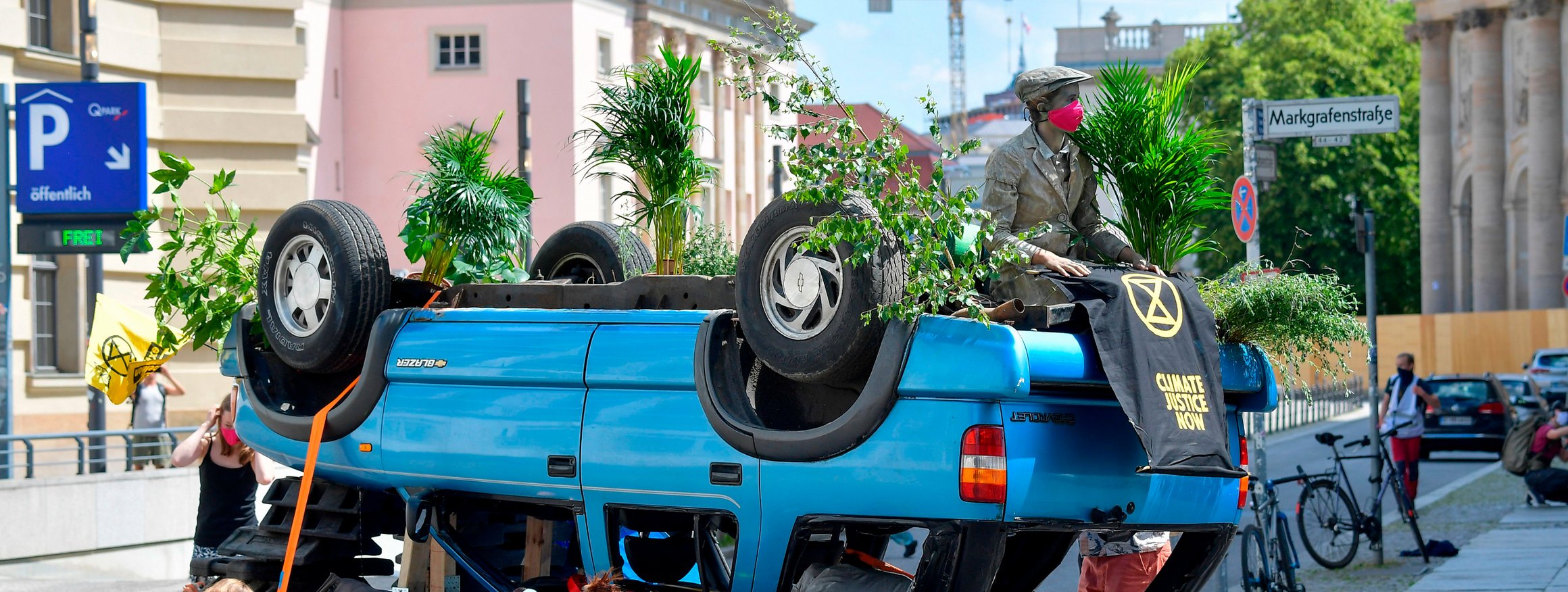 In Berlin demonstrieren im Juni 2020 Klimaaktivisten der Extinction-Rebellion-Bewegung mitten auf der Straße mit einem blauen Auto, das auf dem Kopf steht