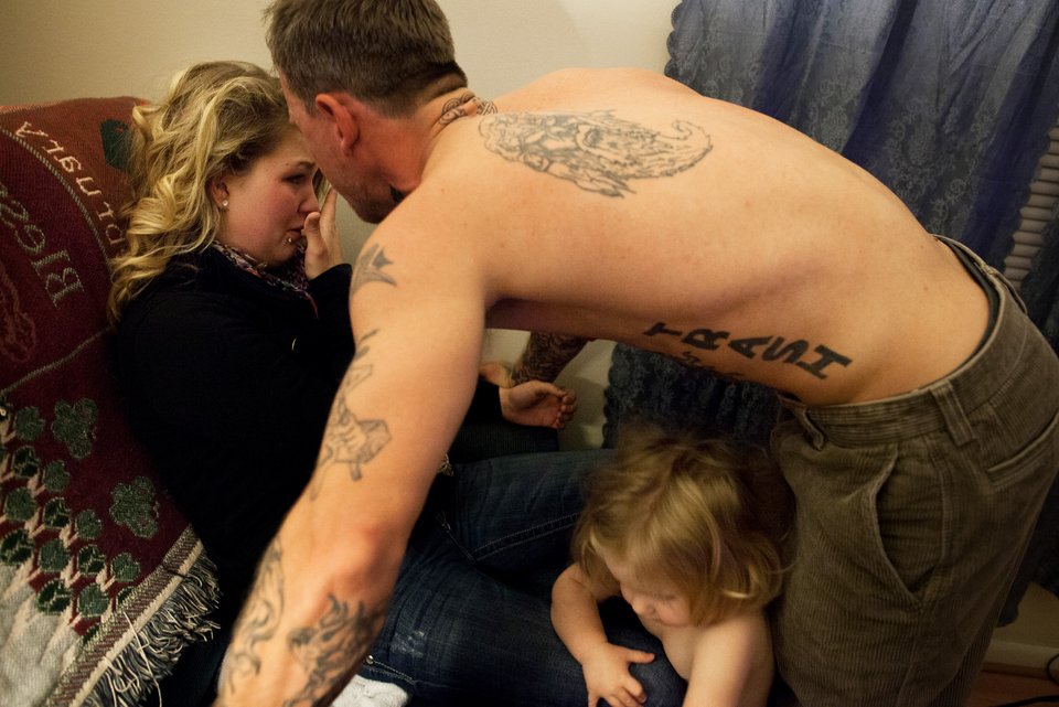 Ein Mann mit Tattoos und nacktem Oberkörper bedroht seine Freundin vor den Augen ihrer zweijährigen Tochter, die sich dazwischen drängt