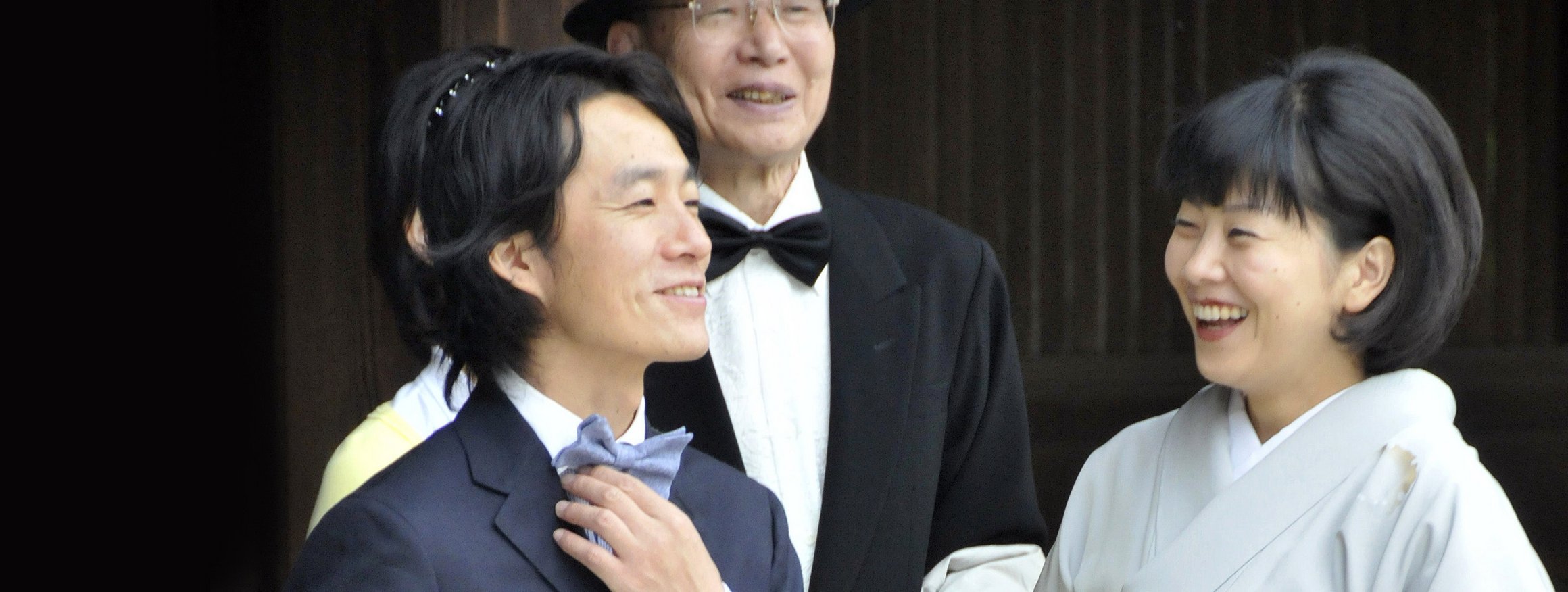 Eine japanische Familie feiert gemeinsam eine Zeremonie und alle lachen dabei herzlich und leben ihre eigene Form von Zufriedenheit