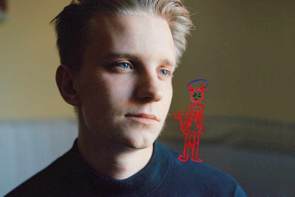 Ein blonder Junge schaut ernst, während ein gezeichneter roter, abgemagerter Teufel mit Dreizack auf der Schulter steht.