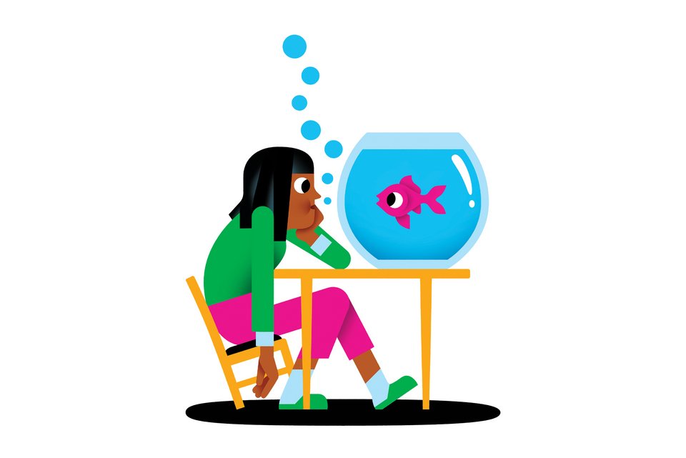 Eine Frau sitzt gelangweilt auf einem Stuhl und beobachtet vor sich auf dem Tisch einen Fisch im Glas