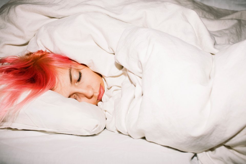 Foto zeigt eine Frau im Bett, die sich der Welt entzieht. 