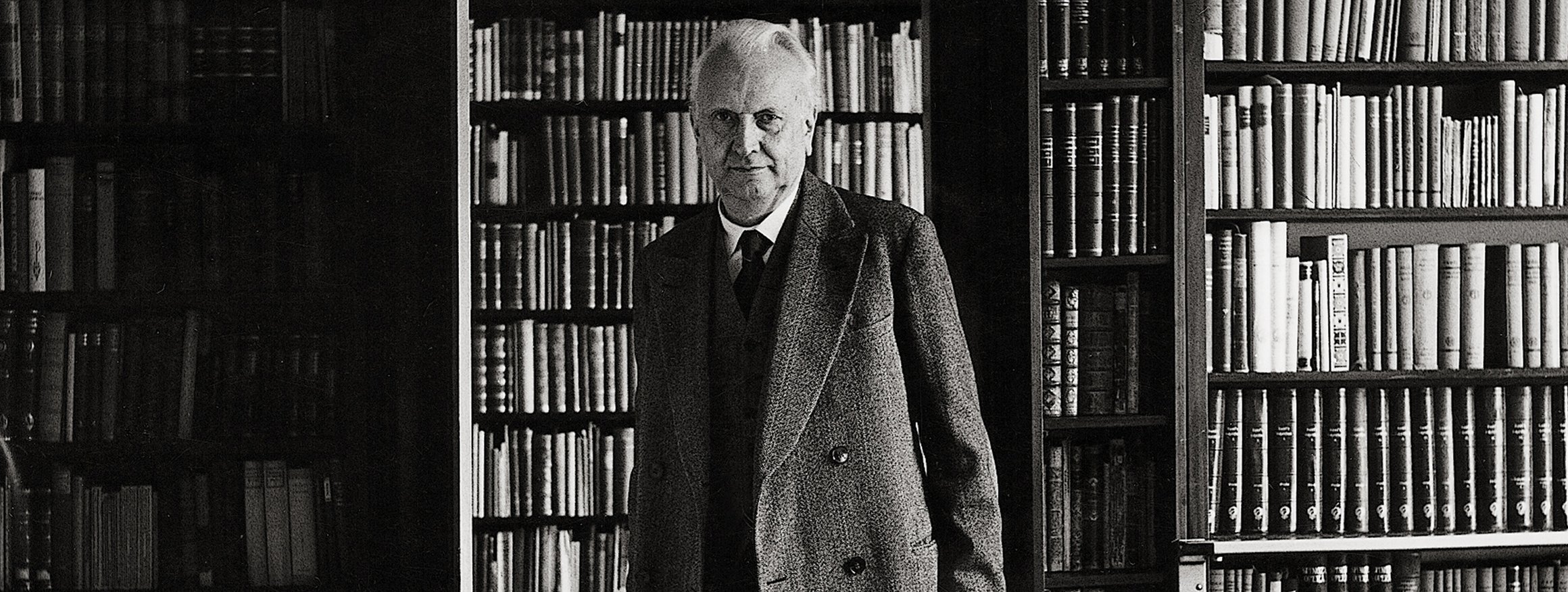 Karl Jaspers steht in einer Tür, hinter ihm eine große Bücherwand