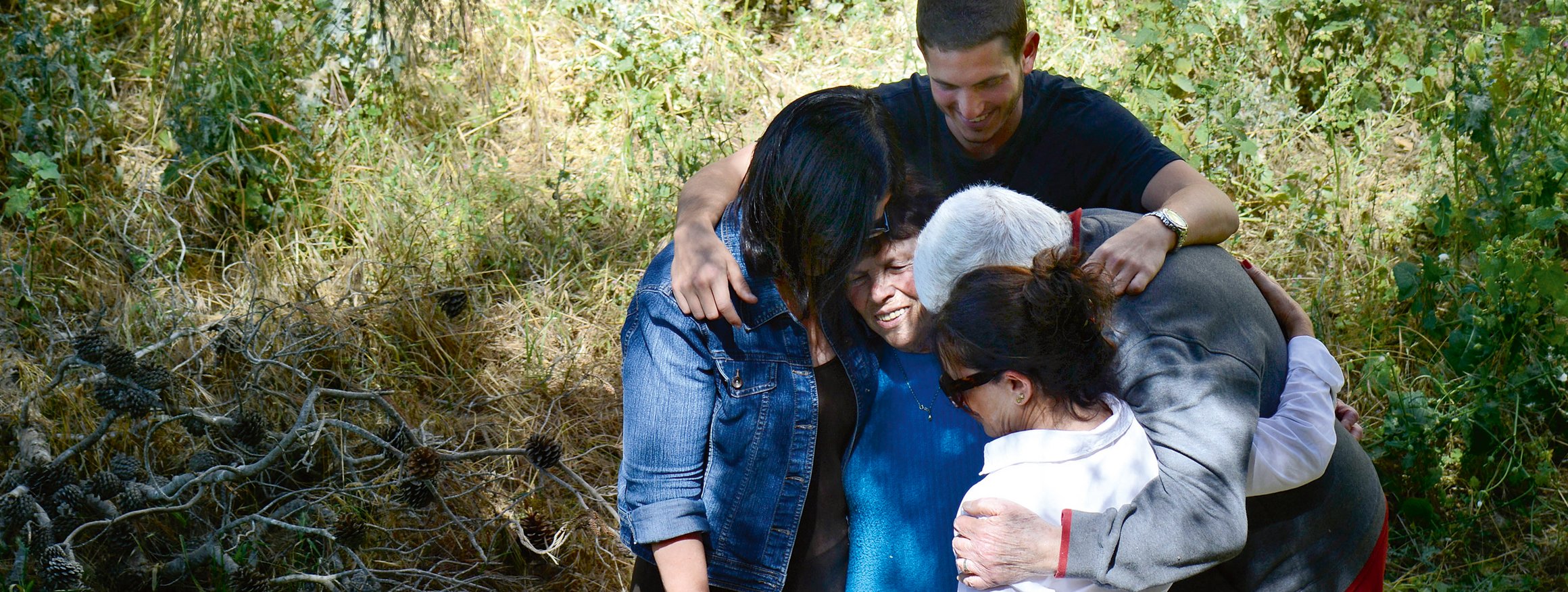 Eine Familie steht in ihrem Garten in Jerusalem und umarmt tröstend ein älteres Familienmitglied