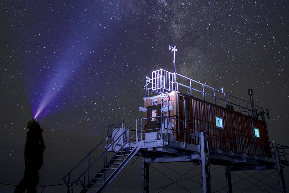 Ein Mann schaut in den Sternenhimmel am Spurenstoffobservatorium der Neumayer-Station in der Antarktis