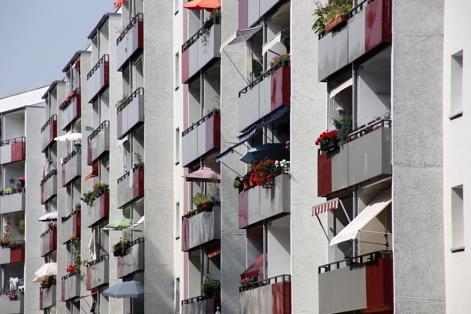 Eine graue Hausfassade eines Miethausblocks in einer Stadt in dem jeder isoliert lebt