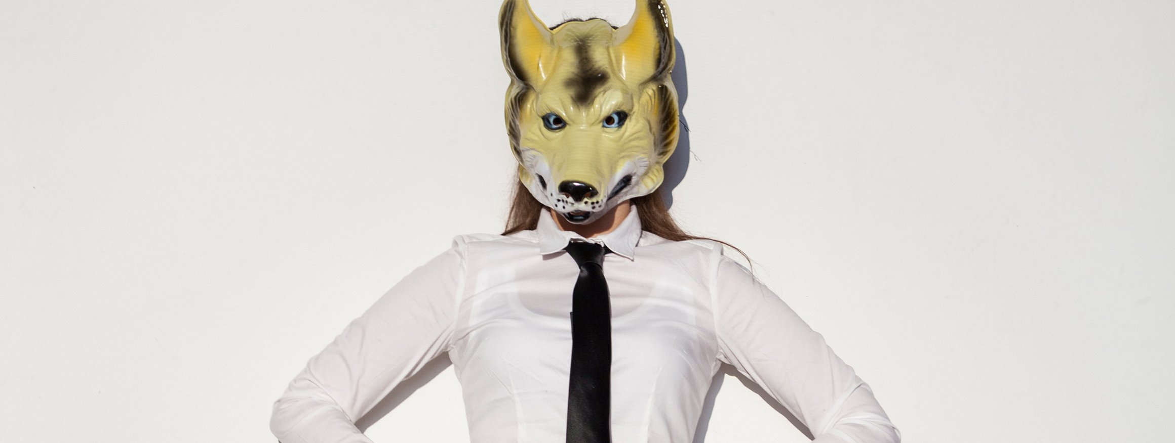Foto zeigt eine narzisstische Frau in Businesskleidung mit Wolfsmaske.