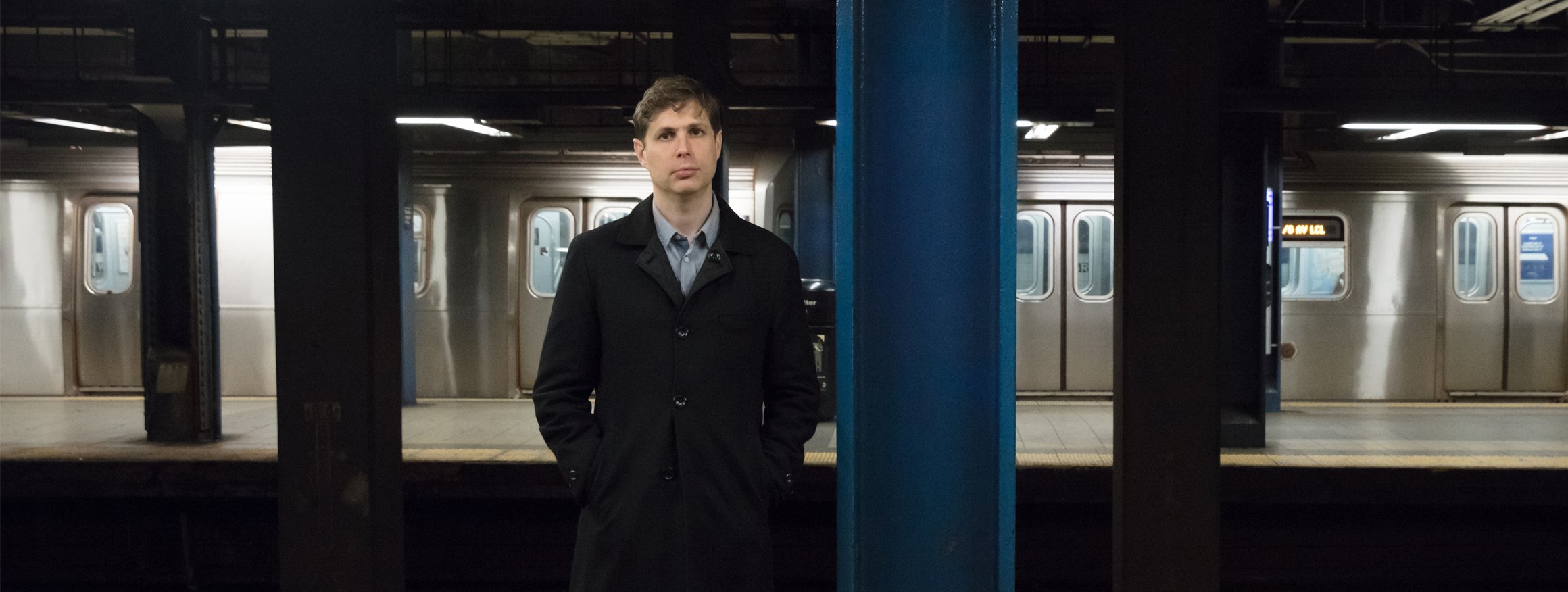 Der Schriftsteller Daniel Kehlmann, einen dunklen Mantel tragend, steht mit den Händen in den Taschen in einer U-Bahn-Station