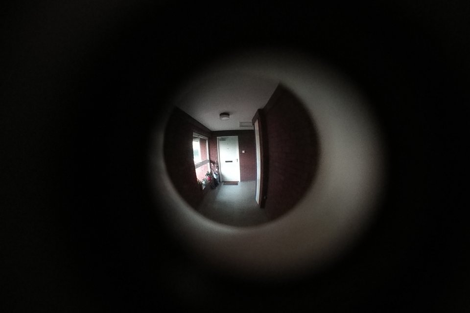 Blick durch den Türspion in einen leeren Flur