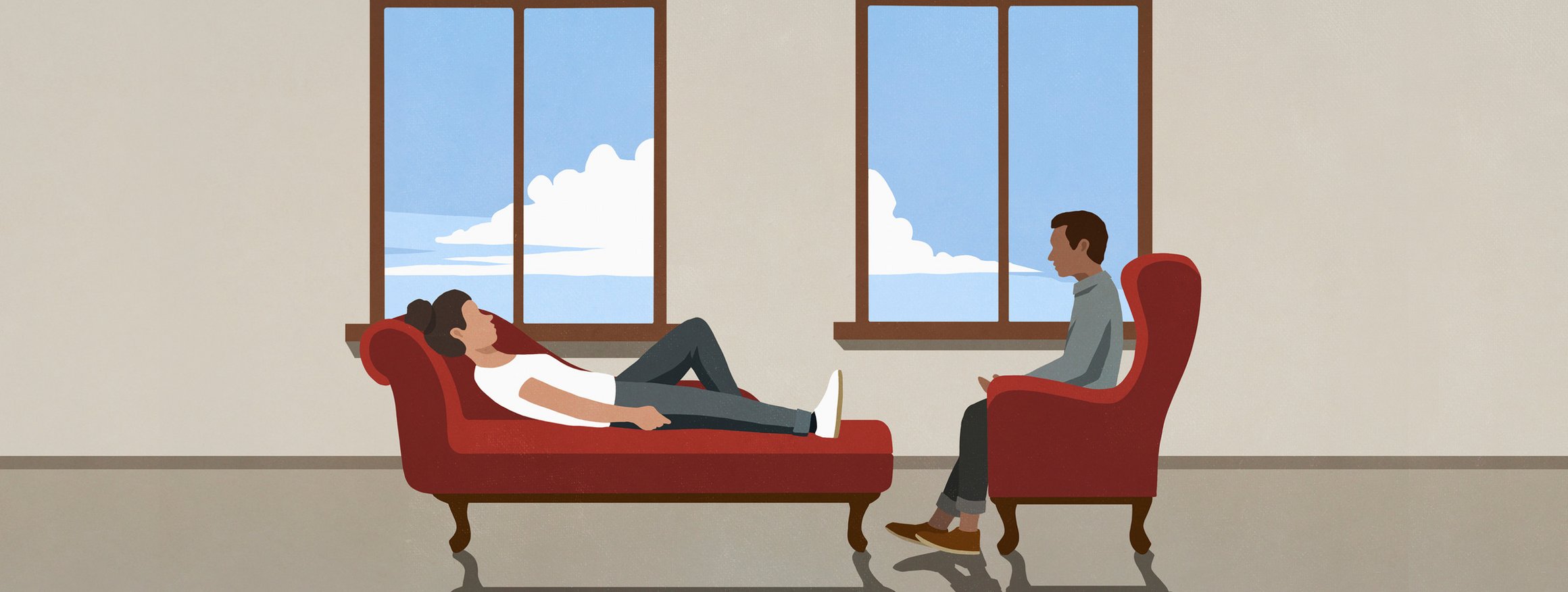 Eine Klientin liegt bei einer Behandlung bei ihrem Therapeuten auf der Couch, während er auf einem Sessel sitzt und zuhört