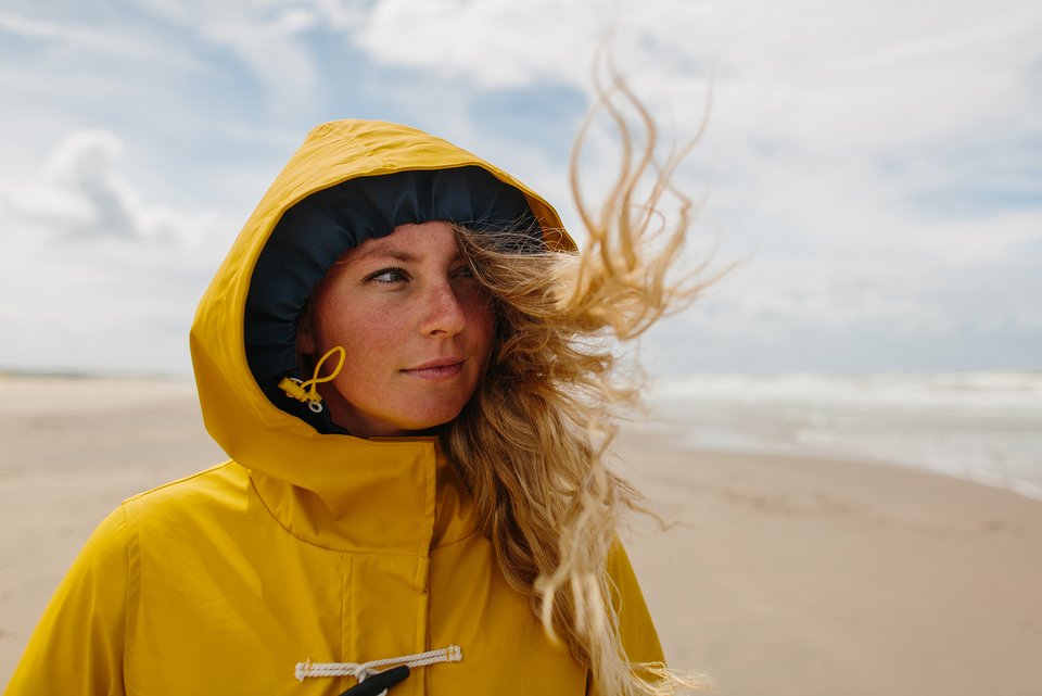 Foto zeigt eine junge Frau am Strand, die nach vorne schaut. 