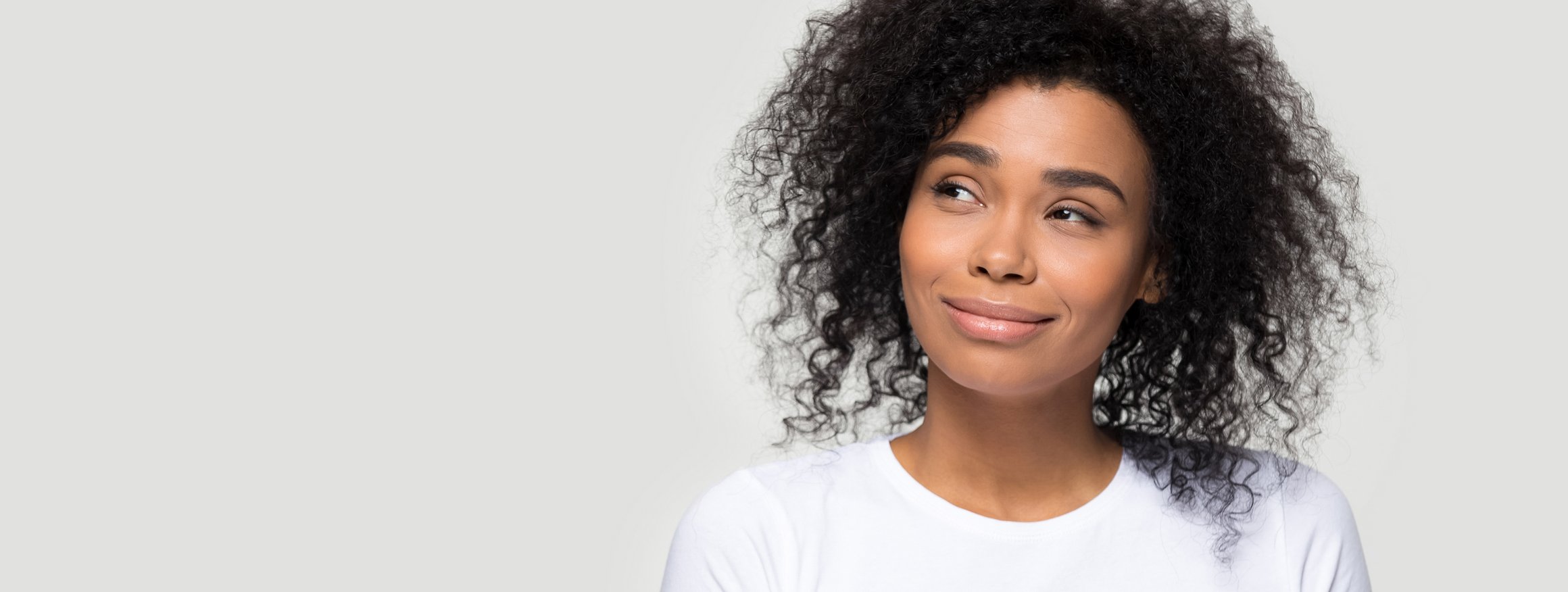 Eine junge Frau  mit weißen T-Shirt und dunklem Lockenkopf fragt sich, ob wir wirklich alle unschuldig sind