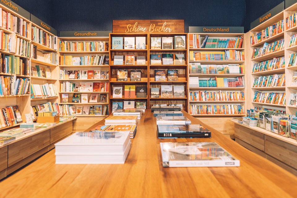 Ein Buchgeschäft mit vielen Büchern in Regalen und auf Holztischen
