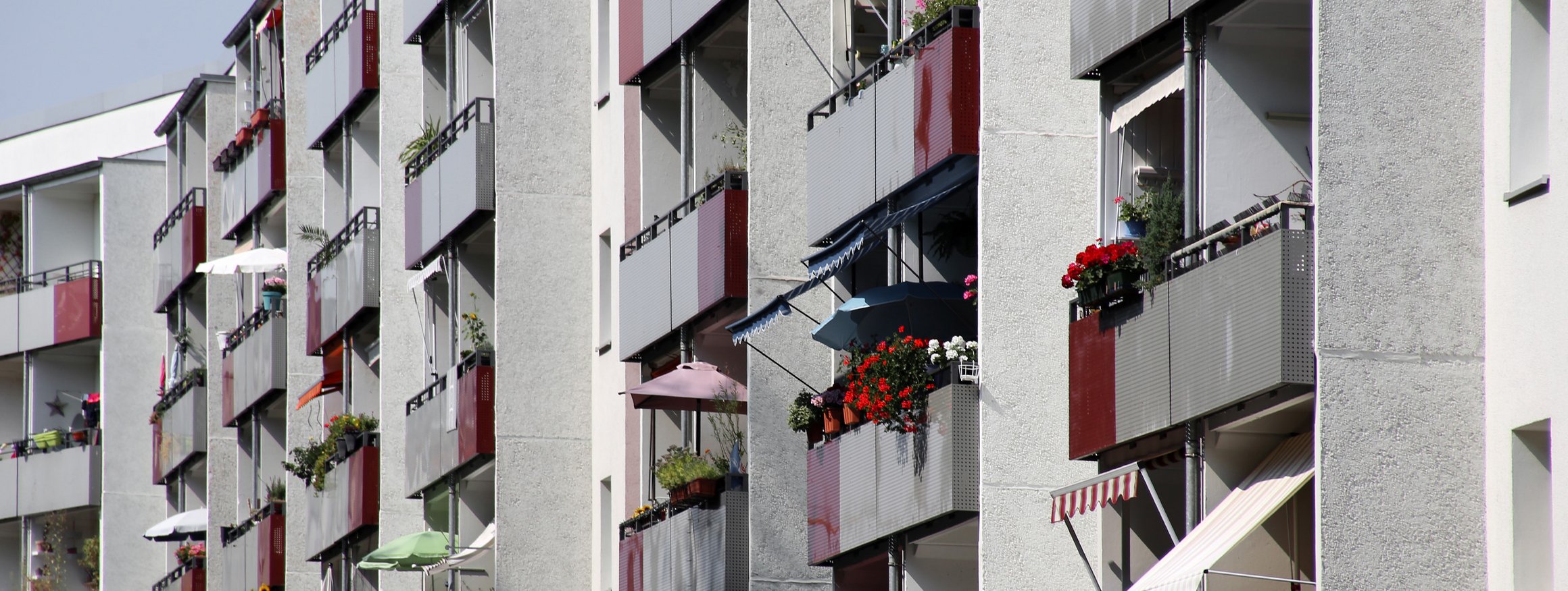 Eine graue Hausfassade eines Miethausblocks in einer Stadt in dem jeder isoliert lebt