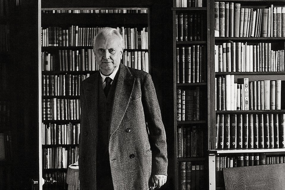 Karl Jaspers steht in einer Tür, hinter ihm eine große Bücherwand