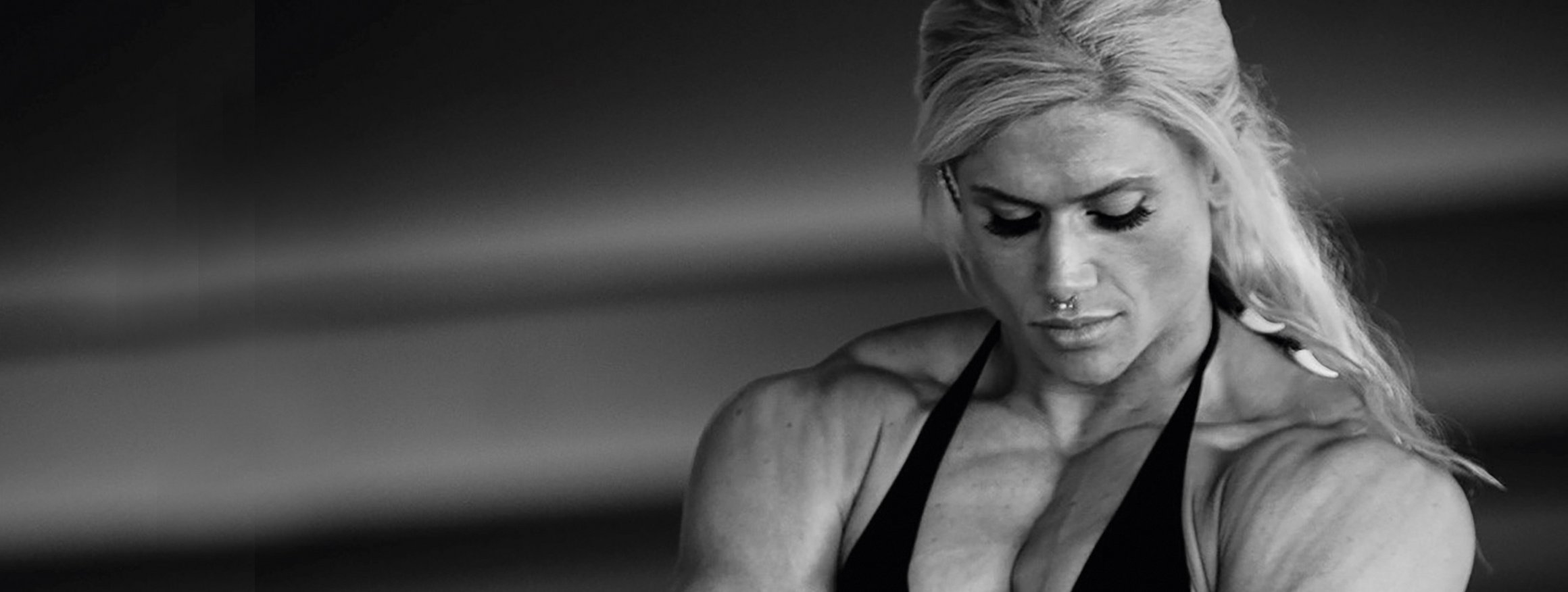 Die Bodybuilderin, Julia Föry, stellt mit langen blonden Haaren und Bikini, in Pose und lässt die Muskeln spielen