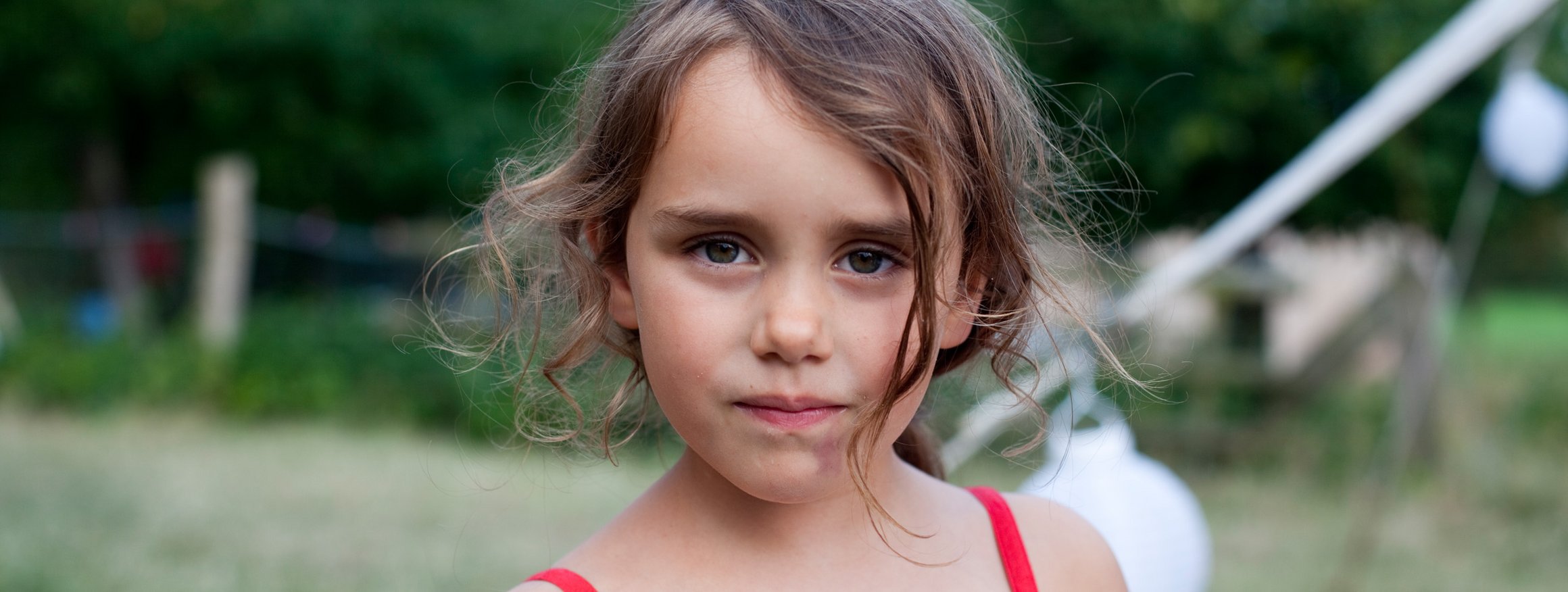 Ein kleines Mädchen mit dunkler Haarsträhne im Gesicht scheint hochbegabt zu sein