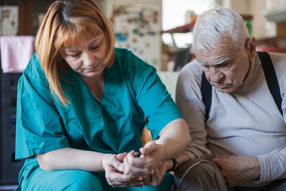 Eine Pflegekraft kümmert sich um einen Patienten