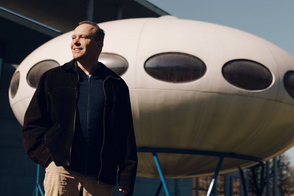 Der Autor Sascha Mamczak steht vor einer Raumschiff-Attrappe