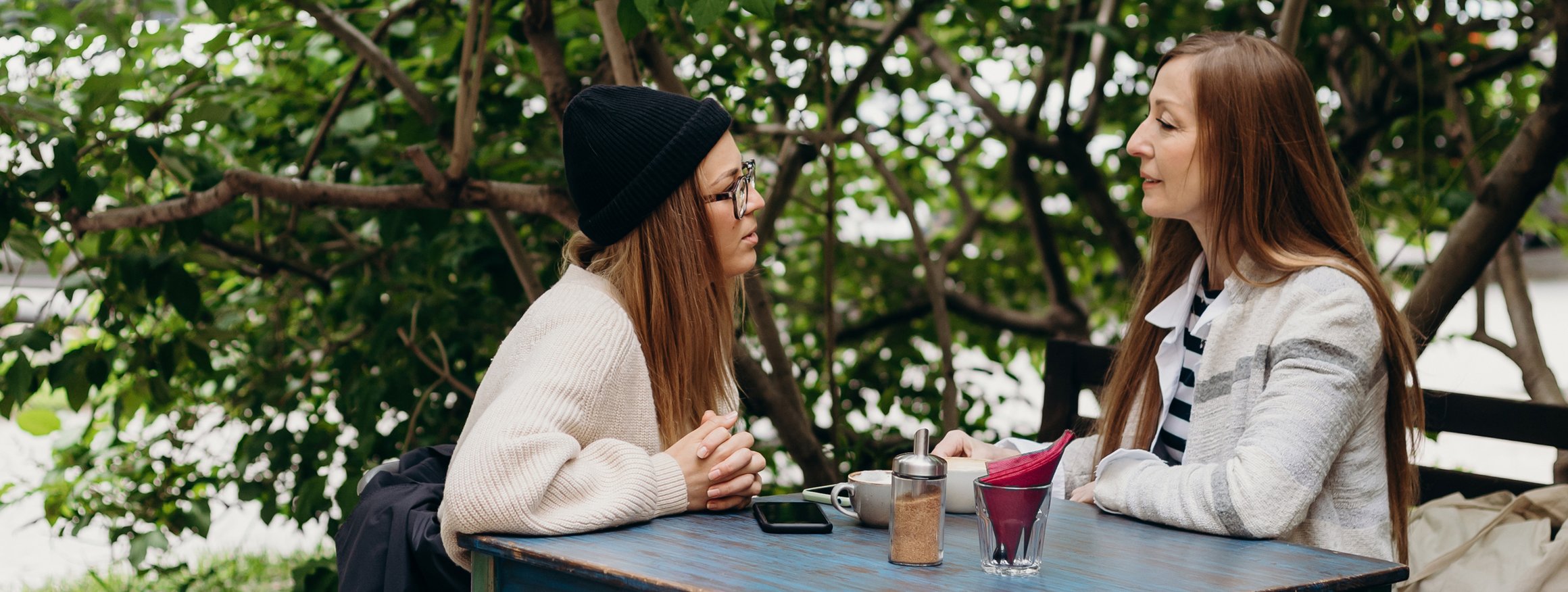 Eine Tochter, die gerade in Therapie ist, sitzt im Cafe mit Ihrer Mutter und macht ihr Vorwürfe