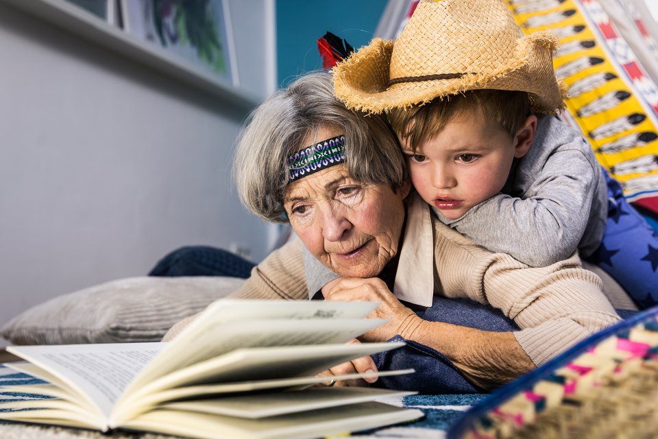 Eine Großmutter liest ihrem kleinen Enkelsohn aus einem Buch vor