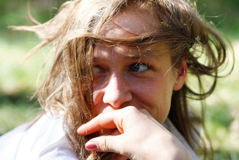 Eine junge Frau mit verwuschelten Haaren, schaut schwärmerisch verliebt