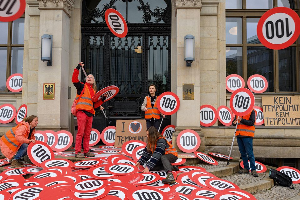 Aktivistinnen und Aktivisten der "Letzten Generation" bringen Tempo-100-Schilder zum Bundesministerium für Digitales und Verkehr in Berlin im Oktober 2022
