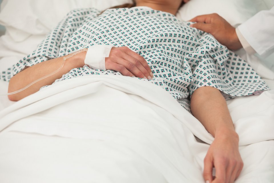 Eine Locked-in-Patientin liegt bewegungslos im Bett und ist in ihrem Körper eingeschlossen