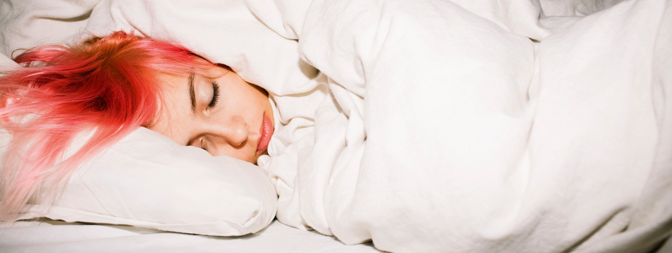 Foto zeigt eine Frau im Bett, die sich der Welt entzieht.