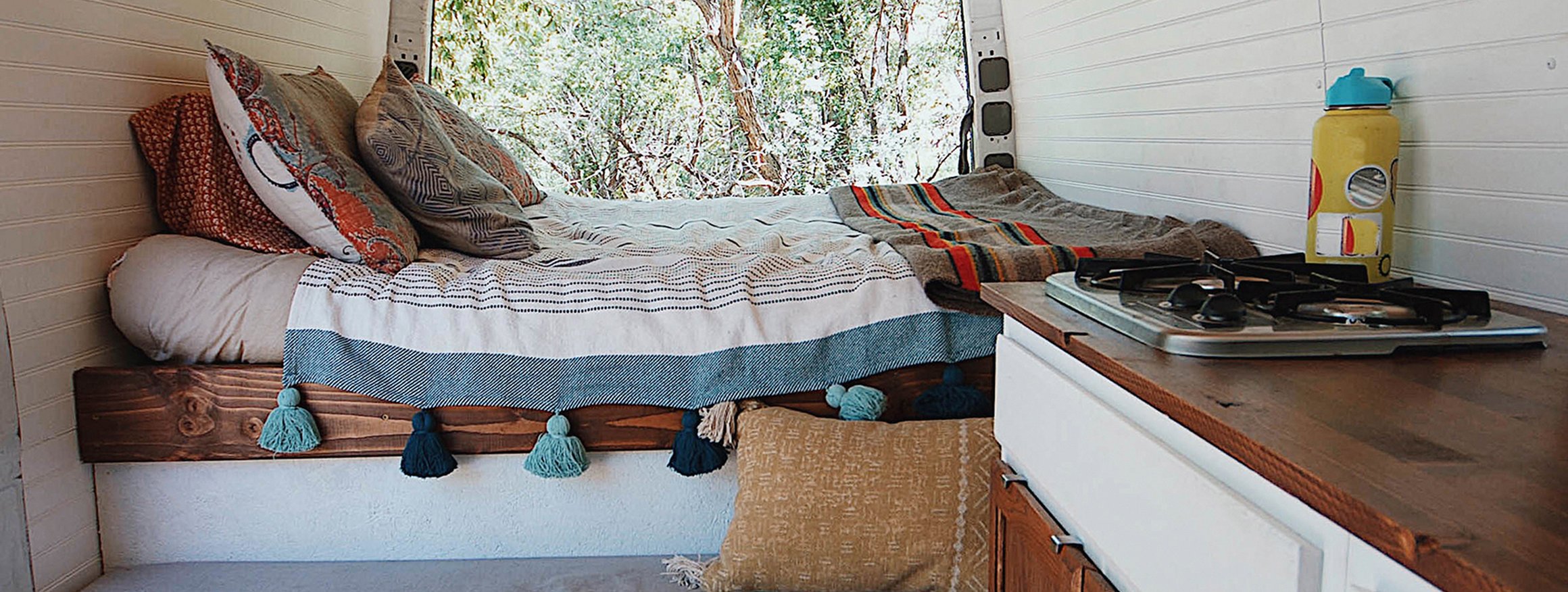 Ein Bett und eine Küchenzeile in einem Tinyhouse