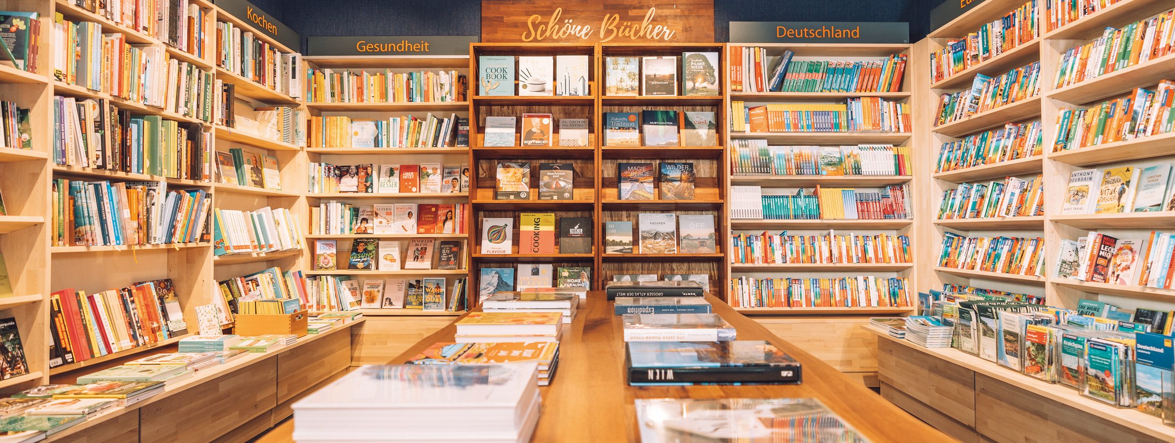 Ein Buchgeschäft mit vielen Büchern in Regalen und auf Holztischen