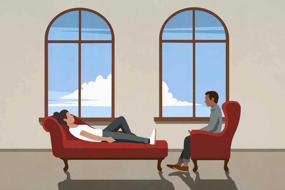 Eine Klientin liegt bei einer Behandlung bei ihrem Therapeuten auf der Couch, während er auf einem Sessel sitzt und zuhört