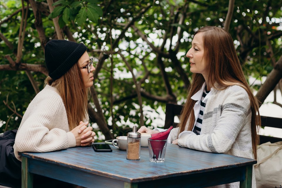 Eine Tochter, die gerade in Therapie ist, sitzt im Cafe mit Ihrer Mutter und macht ihr Vorwürfe