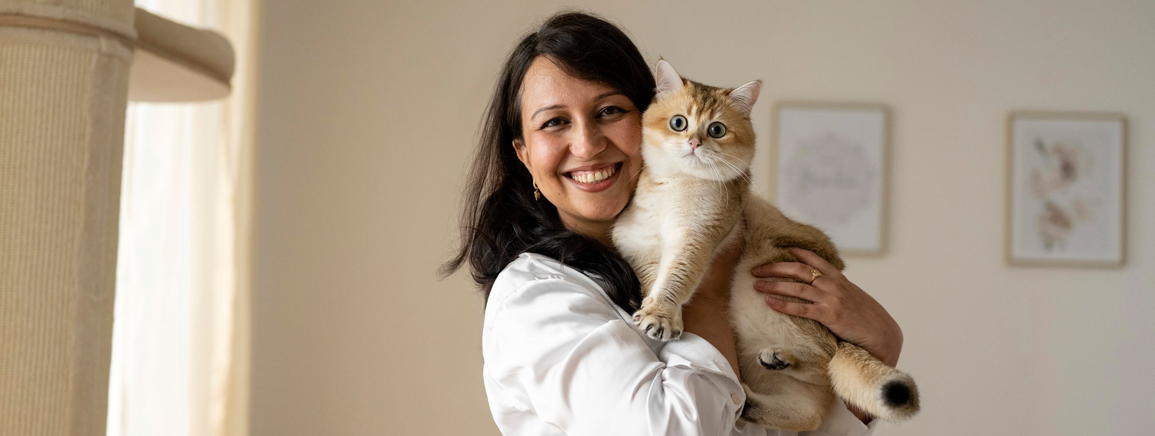 Eine Frau hält lachend eine Katze im Arm und hat keine Angst mehr davor