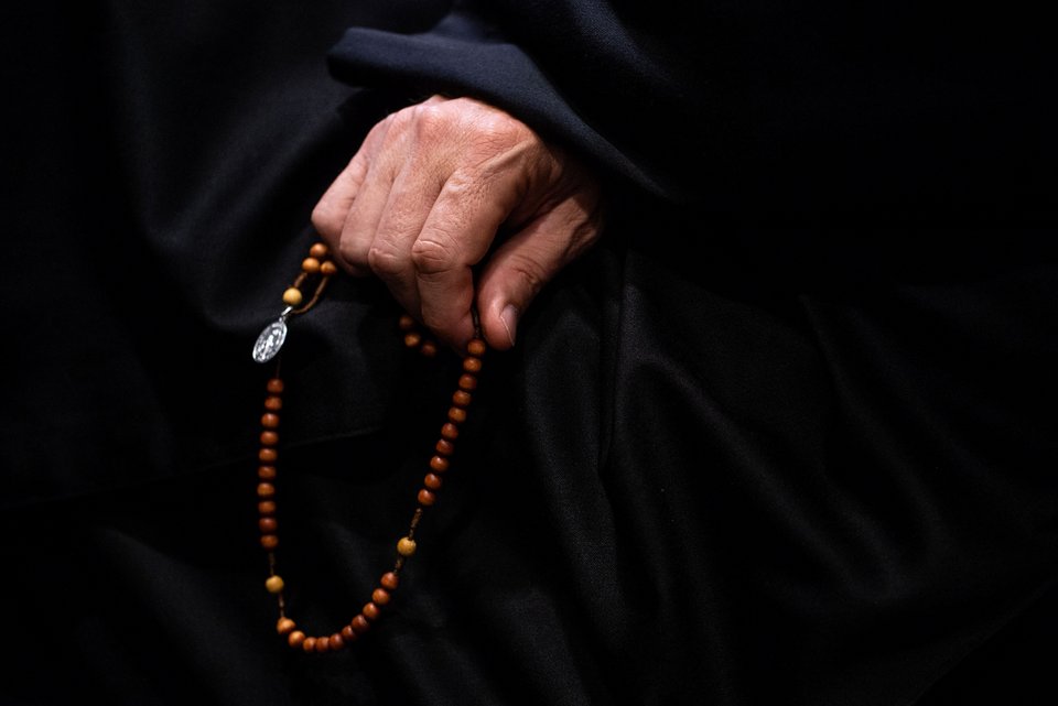 Ein Geistlicher hält in seiner Hand einen Rosenkranz
